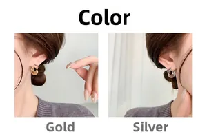 Detail view of gold and silver twisted C-shape hoop earrings on a fashion model