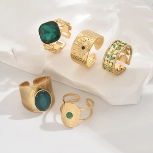Five-piece vintage gold adjustable ring set with green gemstones on white stone