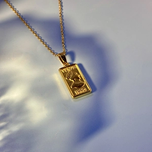 Vintage gold Venus portrait pendant necklace with 1990 engraving on light blue background