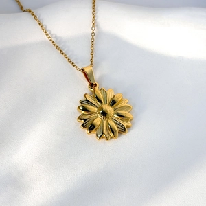 Collana in acciaio inossidabile 304 con ciondolo a margherita dorata su tessuto bianco