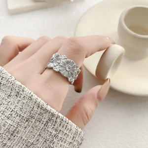 Dettaglio anello a margherita vintage in argento con fiori a rilievo sull'indice