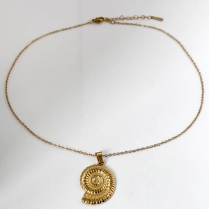Golden ocean style necklace with spiral seashell pendant and adjustable chain on white background