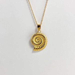 Golden nautilus shell pendant necklace with spiral texture on minimalist white background