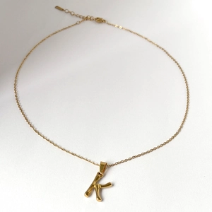Collier en acier inoxydable doré avec un pendentif lettre K minimaliste en relief