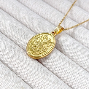 18k gold plated oval St. Michael relief pendant necklace on beige jewelry box