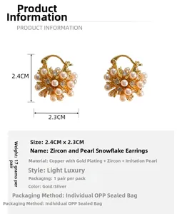 Detail shot of gold-plated snowflake earrings with shimmering pearls and zircons