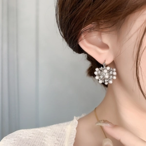 Elegant snowflake pearl earrings with gold plating and zircons worn by model
