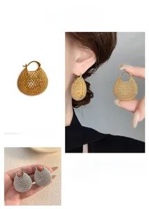 Detailed view of hollow gold and silver pouch earrings featuring intricate mesh craft