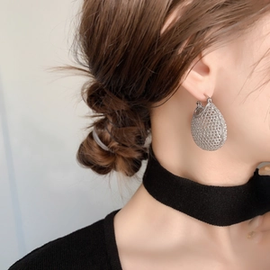 Elegant hollow mesh water-drop earrings in silver finish on a female model