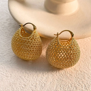 Detail shot of vintage hollow gold-plated money bag earrings with woven mesh texture