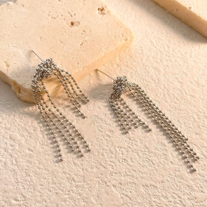 Detailed macro view of silver tassel chain earrings with spherical link design