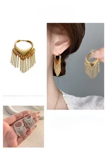 Détail de boucles d'oreilles cœur en V dorées avec franges métalliques pendantes élégantes