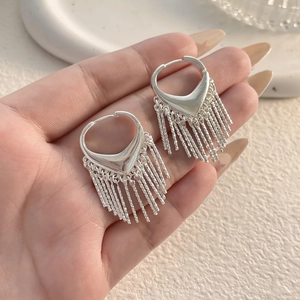 Détail de boucles d'oreilles argentées à pampilles avec fermoir cœur et fines chaînes