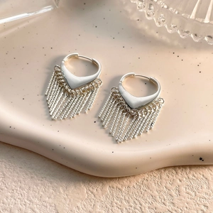 Vue détaillée des boucles d'oreilles à pompons argentés avec fermoirs en cœur