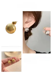 Detailed macro view of 18k gold and silver plated spherical stud earrings with scale texture