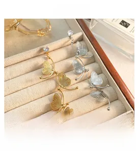 Macro detail of gold and silver butterfly tassel earrings with cubic zirconia studs