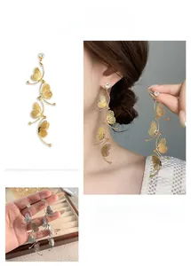 Detailed view of hollow butterfly tassel earrings with cubic zirconia in gold and silver