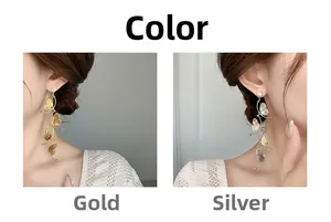Close-up of dangling hollow butterfly tassel earrings in gold and silver finish with zircon