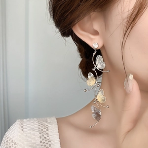 Detail of elegant butterfly tassel earrings with zircons shown on a model