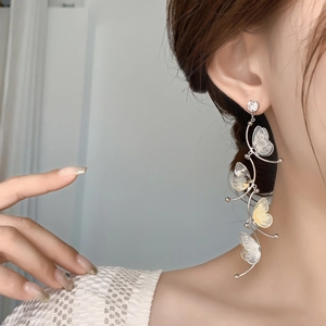 Silver needle butterfly tassel earrings with zircon studs worn on ear for elegant style