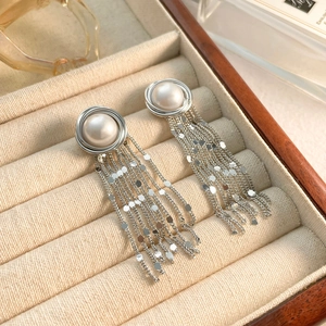 Detail of silver tassel earrings with white pearls and shimmering chain sequins
