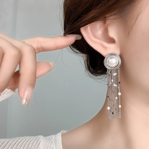 Elegant silver waterfall earrings with large pearls and shimmering sequin tassels on model