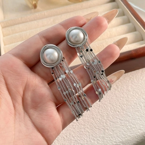 Detailed shot of long tassel pearl earrings with silver chains and shimmering sequins