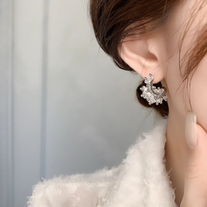 Close-up of U-shaped horseshoe stud earrings with crystals on a female model