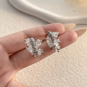 Macro shot of silver U-shaped horseshoe stud earrings with intricate crystal clusters