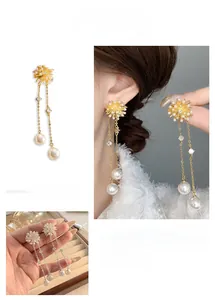 Detailed close-up of long snowflake tassel earrings with white pearls and sparkling zircons