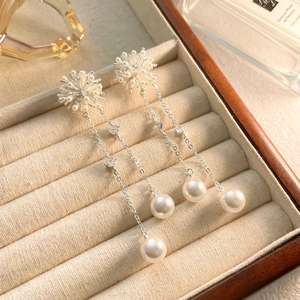Close-up of long tassel pearl earrings with zircon inlay on a velvet jewelry tray