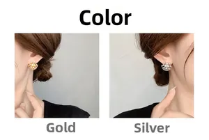 Close-up of sparkling snowflake stud earrings in gold and silver on model's ear