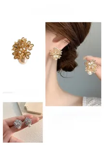 Close-up of sparkling flower stud earrings with micro-inlaid zircon and white pearls