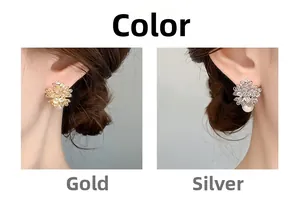 Detail view of flower earrings with sparkling zircons and pearls in gold and silver