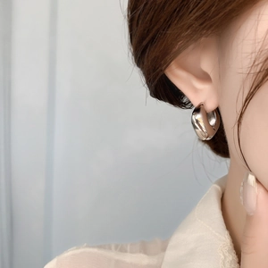 Vue détaillée de boucles d'oreilles cœur dorées polies sur modèle avec éclat métallique