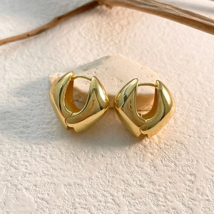 Gros plan détaillé de boucles d'oreilles cœur dorées avec finition poli miroir