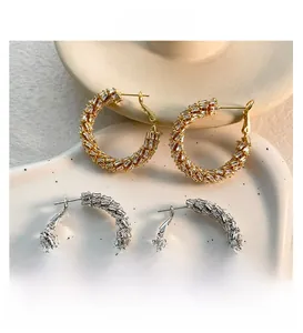 Detailed view of gold and silver hoop earrings featuring baguette-cut cubic zirconia settings