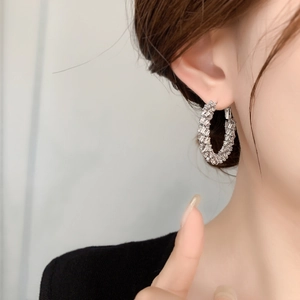 Luxe C-shaped hoop earrings with shimmering crystals worn on model for a premium look