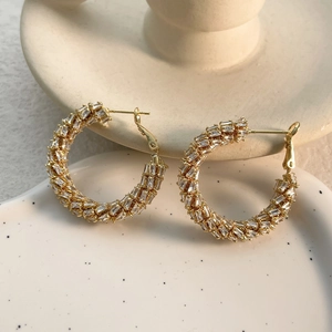 Detailed view of gold hoop earrings featuring multi-row rectangular zircon crystal inlay