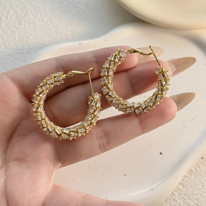 Elegant gold hoop earrings with baguette cut zircon inlay in a luxurious geometric wheat design