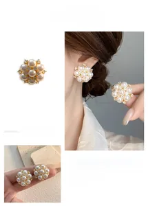 Detail of vintage flower stud earrings featuring white pearls and zircon crystals