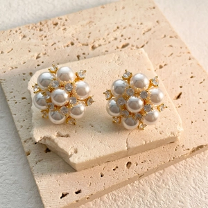 Elegant gold flower earrings with white pearls and sparkling cubic zirconia stones
