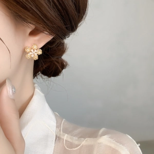 Macro shot of 18K gold plated snowflake earrings with frosted petals and white pearls