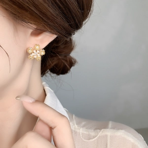 Detailed view of 18K gold plated snowflake earrings with zircons and pearls on ear