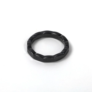 Detailed view of the wave-patterned black ceramic ring with a polished minimalist finish