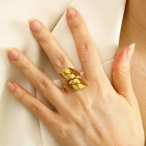 Close-up of elegant gold leaf-shaped adjustable ring with detailed metallic texture