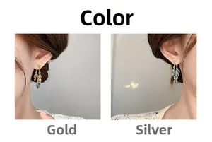 Detail view of mint blue zircon tassel earrings in gold and silver finish on model