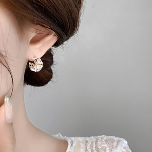 Detailed close-up of a square zircon stud earring with 18K gold-plated setting on ear