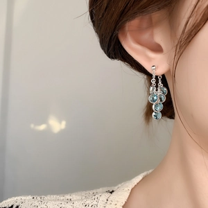 Mint blue zircon tassel drop earrings in silver finish worn by a fashion model