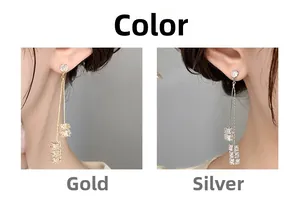 Détail de boucles d'oreilles longues à pampilles avec cubes de cristal dorés et argentés